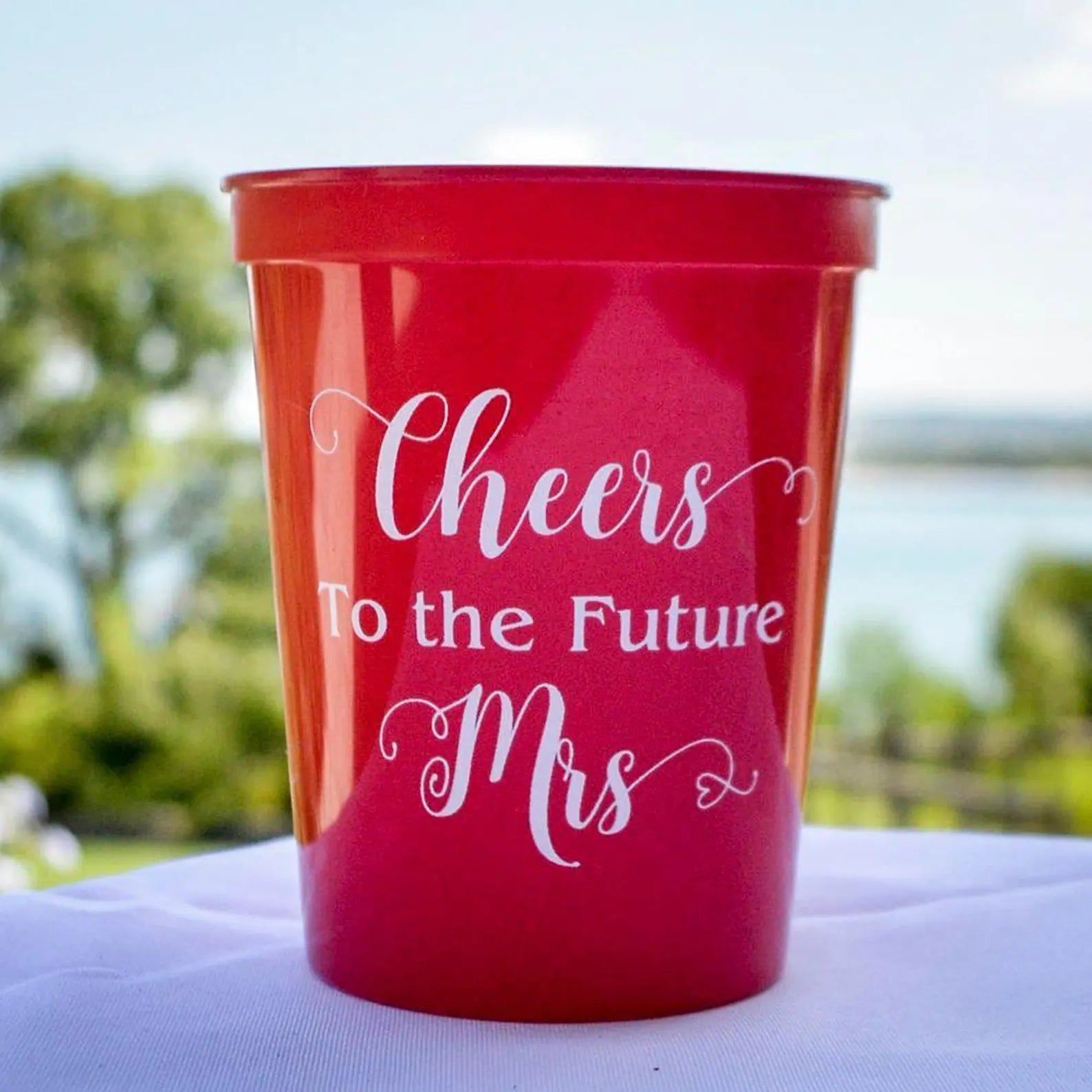 A red plastic cup with the text "Cheers To The Future Mrs" printed on it.